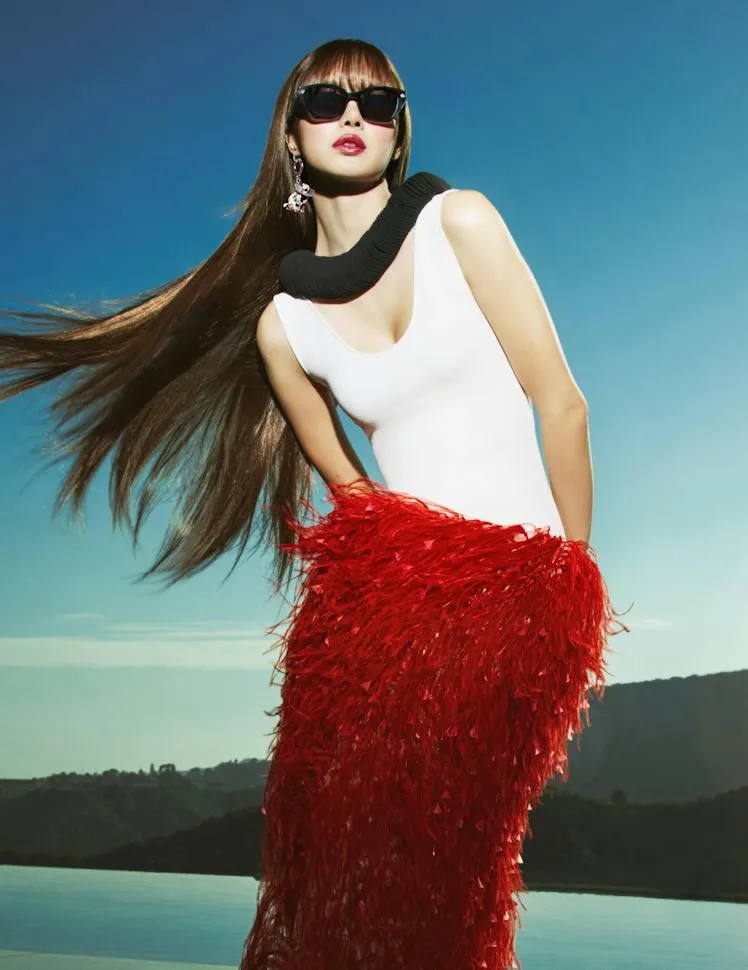 ลิซ่าใส่แว่นกันแดด Meta Capri LISA Edition ผมยาวปลิว กับกระโปรงขนนกสีแดงริมน้ำ