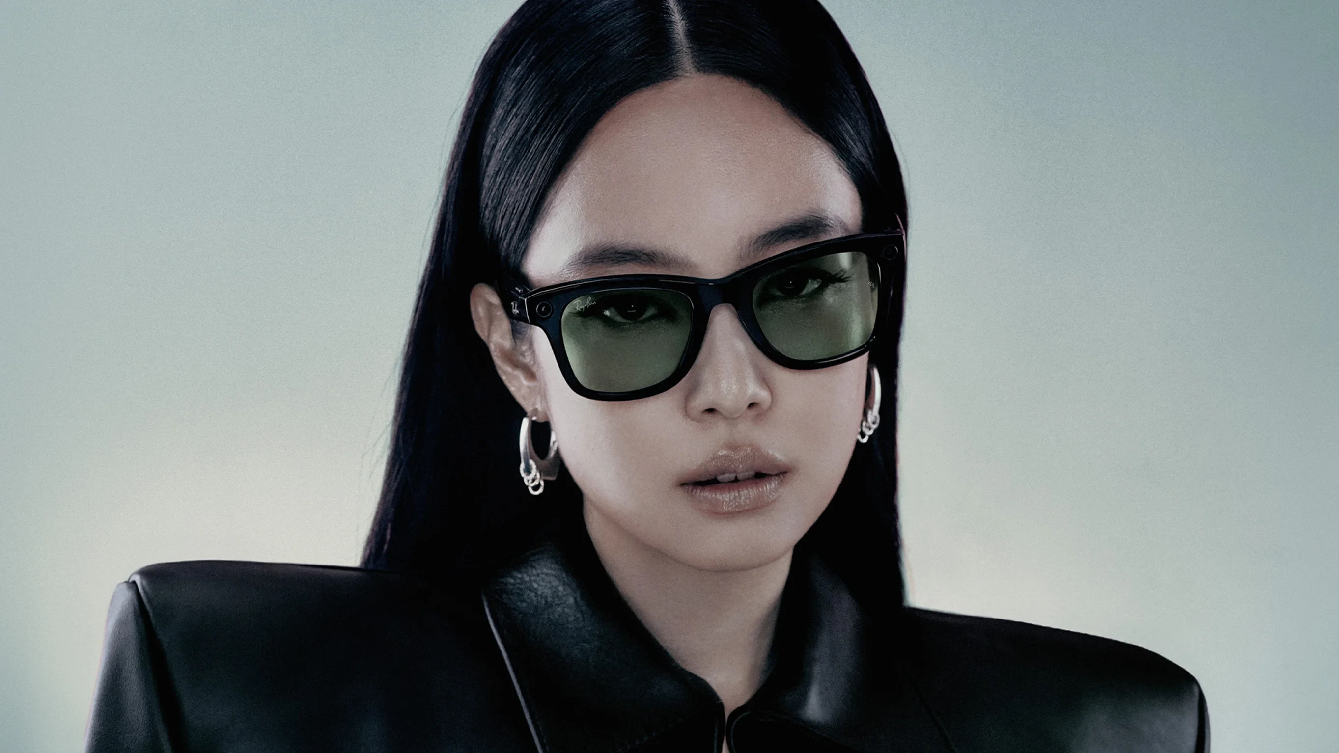 JENNIE wearing Rayban Meta Wayfarer glasses with Shiny Black frames with Green Transitions® lenses.